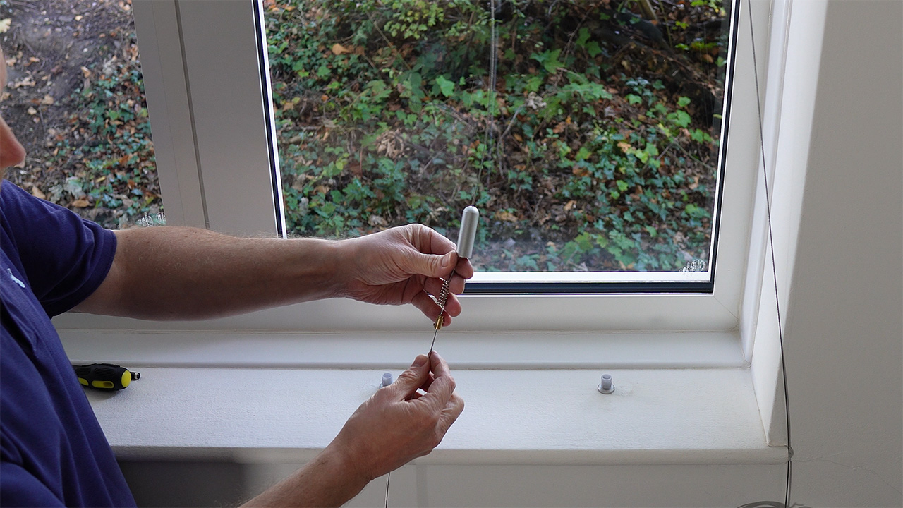 Sliding the spring and the adjustable brass nipple further up the cable prior to cutting the cable to length.