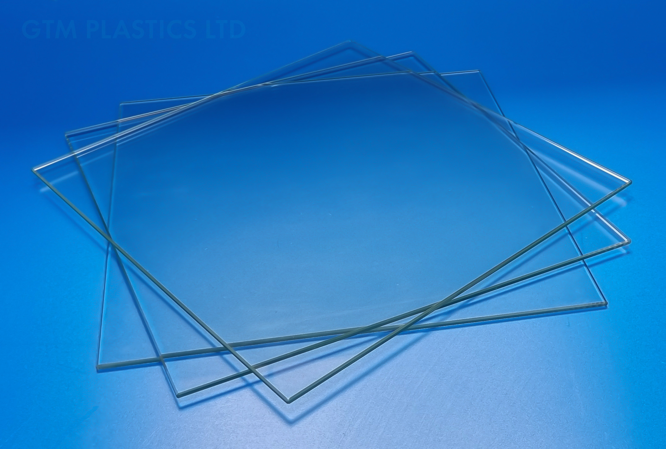 Three glass cube display panels sitting flat, staggered on top of one another, which are used in our flat-pack cube display kits.