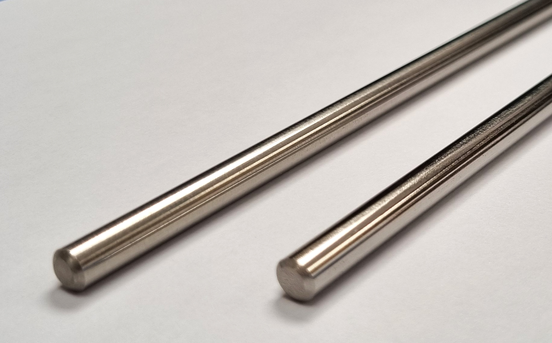 Two lengths of 6mm diameter stainless steel rod placed side by side, which are used in our hook-on pocket poster display kits.