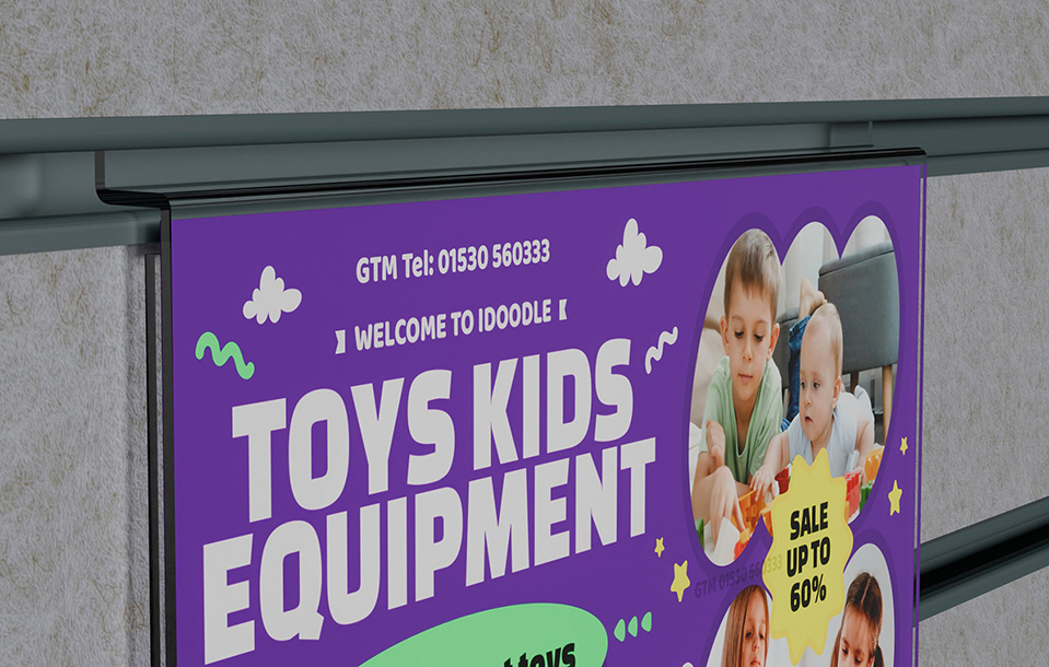 A zoomed in photo of an acrylic slatwall landscape poster holder that is advertising kids toys and equipment. The shape of the slatwall section is clearly visible.