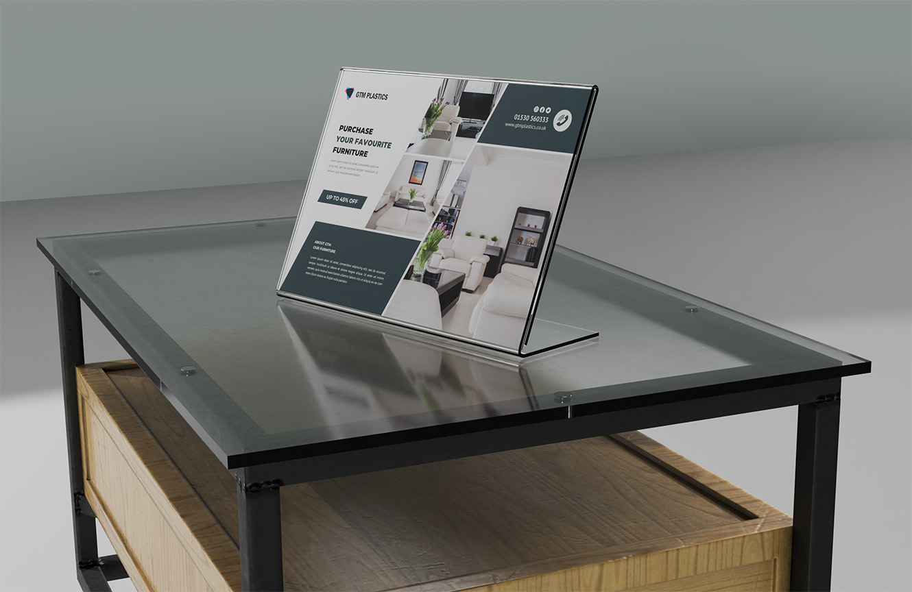 A sloping acrylic poster holder sitting on a glass top dining table. The poster is advertising 45 percent off your favourite furniture.