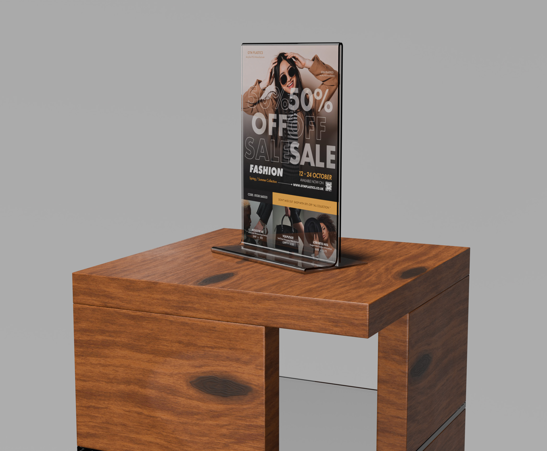 A free-standing upright acrylic poster holder placed on a small square wooden table which has a glass shelf. The poster is advertising 50 percent discount on fashionable clothes.