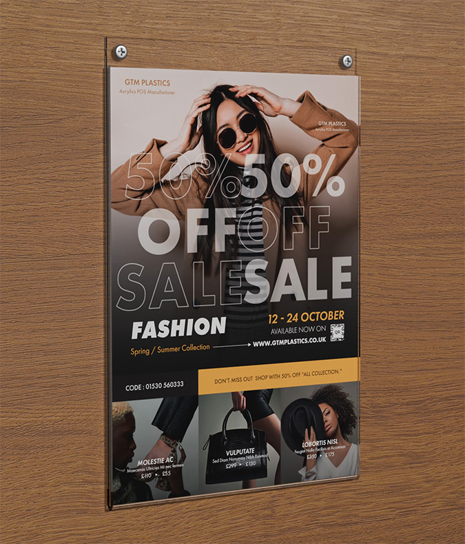 An acrylic wall mounted portrait poster holder attached to the wall with two screws. The poster is advertising a clothes fashion sale.