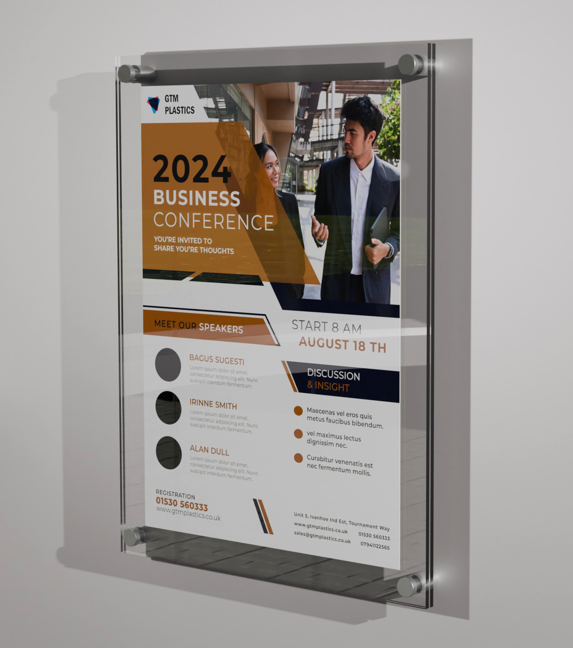 A poster sandwiched between two acrylic panels. Four stand-off clamps attach the display to the wall, portrait. The poster is advertising a business conference.