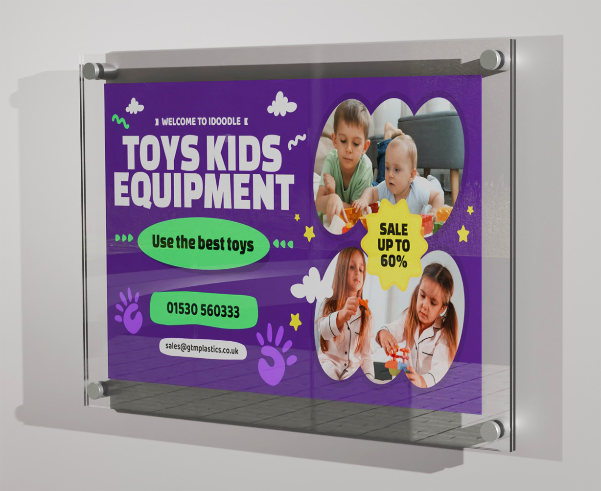 A poster sandwiched between two acrylic panels. Four stand-off clamps attach the display to the wall, landscape. The poster is advertising kids toys equipment.